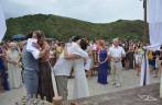 Abraço apertado nos amigos, padrinhos e noivos durante a cerimônia de casamento na Praia Grande, na Ilha do Mel, no litoral do Paraná